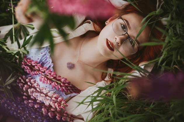 Creative Highlights Symbolbilder Teenage girl lying on grass with lupin flowers model released, Symbolfoto, IEF00266