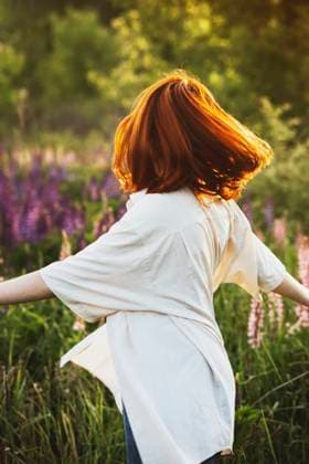 Creative Highlights Symbolbilder Redhead girl spinning on field at sunset model released, Symbolfoto, IEF00277