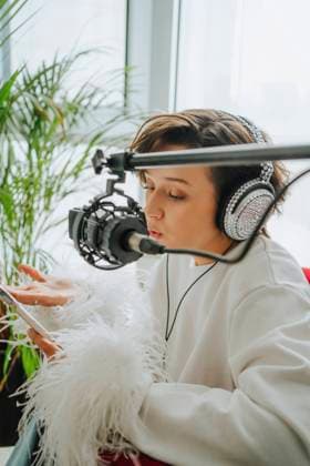 Musician wearing headphones recording podcast through microphone in studio model released, Symbolfoto property released, MDOF00331