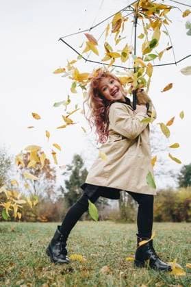 Creative Highlights Symbolbilder Happy girl holding umbrella with leaves falling in park model released, Symbolfoto, MDOF00406