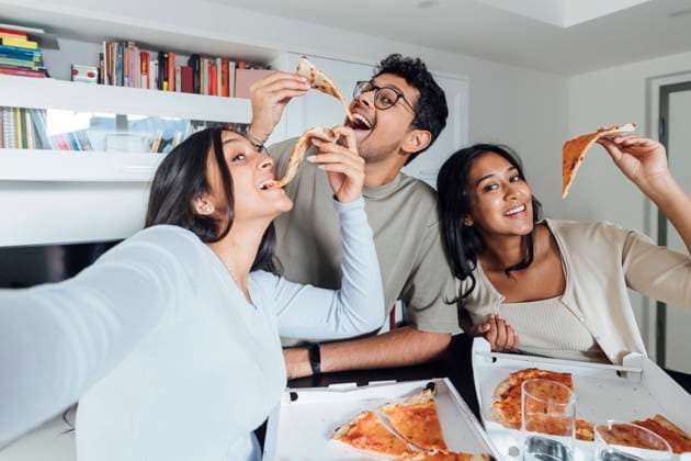 IMAGO Creative, Lifestyle, Leben in einer Wohngemeinschaft, WG Happy young woman taking selfie with woman and man having pizza at home model released, Symbolfoto property released, MEUF08632