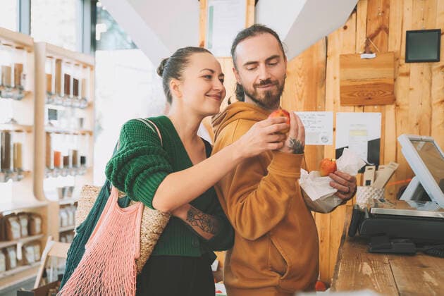 Couple looking at apple near checkout counter in shop model released, Symbolfoto property released, NDEF00208