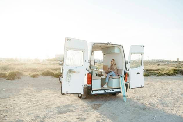 Young freelancer sitting with laptop in caravan in front of clear sky model released, Symbolfoto property released, RCPF01496