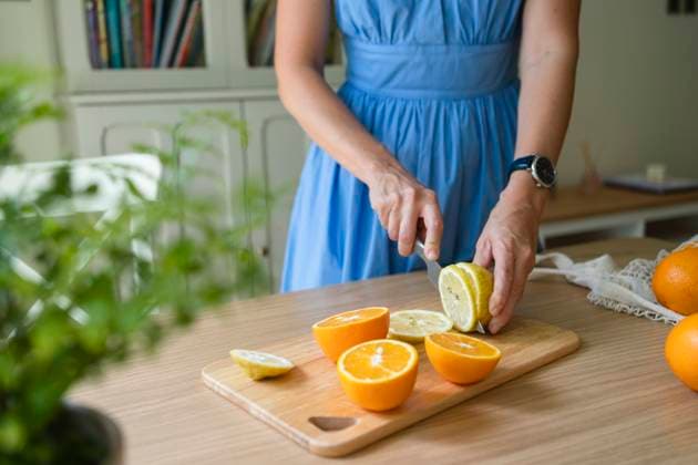 Hands of woman cutting lemons and oranges on table at home model released, Symbolfoto property released, SVKF00784
