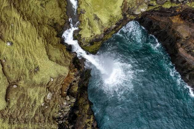 Creative Highlights World Mulafossur waterfall amidst rocky mountain, WPEF06824