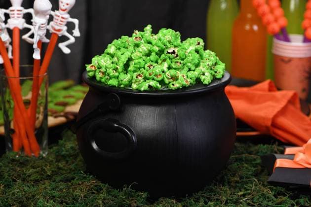 Cauldron corn. Halloween treat Cauldron green sweet popcorn for ghouls and zombies. Halloween treat Copyright: xZoonar.com MarynaxVoronovax 14460863