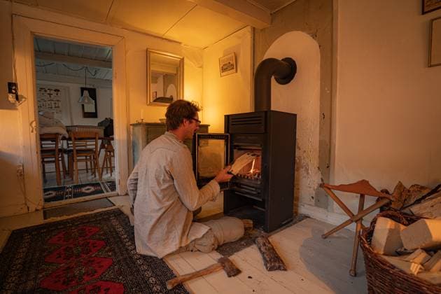 Man Adding Logs To A Wood Burning Stove Fire Breum, Denmark R_EUSL221229-1016571-01 ,model released, Symbolfoto