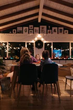 Family sitting at a table at night surrounded by christmas light Laguna Niguel, California, United States R_YFEU230103C2-1095321-01 ,model released, Symbolfoto