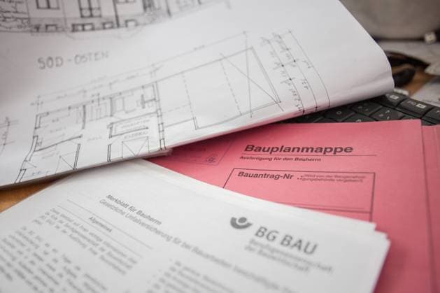 Bamberg, Deutschland 06. Januar 2023: Themenbilder - Symbolbilder - Hausbau Auf einem Tisch liegt eine Bauplanmappe mit der Kostenschätzung für den Bauherrn, daneben die Zeichnung des geplanten Hauses vom Architekten. Unteranderem gibt es auch weitere Unterlagen, wie ein Merkblatt von BG Bau, Berufsgenossenschaft Bau damit beim bauen des Eigenheims alles glatt geht. Bayern *** Bamberg, Germany 06 January 2023 Topic Images Symbol Images Building a house On a table is a construction plan folder with the cost estimate for the builder, next to the drawing of the planned house from the architect Unteranderem there are also other documents, such as a leaflet from BG Bau, Berufsgenossenschaft Bau so that when building your own home everythin Copyright: xFotostandx xK.xSchmittx