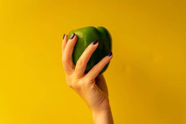  Frauenhand mit einem Gemüse auf gelbem Hintergrund, gesundes Leben, eine grüne Gurke *** Women s Hand with a Vegetables at yellow Background, Healthy Life, a green Cucumber Copyright: imageBROKER/UnaixHuizi ibxuhu08936635.jpg ,model released, Symbolfoto ,property released