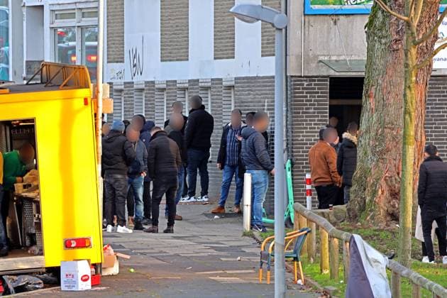 Kritische Orte im Ruhrgebiet BEARBEITET LAUT DSGVO: Überwiegend Männer verschiedener Altergruppen mit Migrationshintergrund sammeln sich an einem Straßenrand Essen Nordrhein-Westfalen Deutschland Huttrop *** Critical places in the Ruhr BEARBEITET LAUT DSGVO Predominantly men of different age groups with migration background gather at a roadside Essen North Rhine Westphalia Germany Huttrop