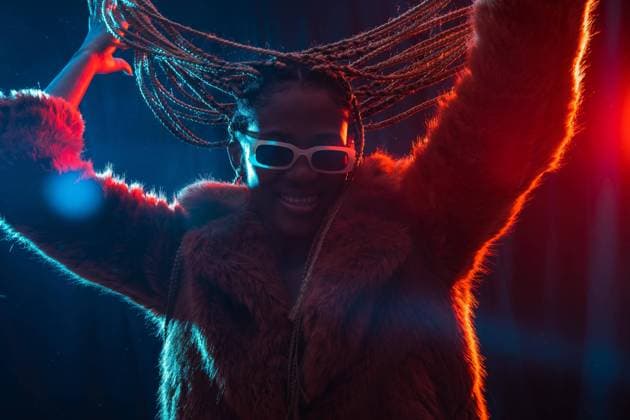  Schwarze ethnische Frau mit Zöpfen mit blauen und roten Lichtern, die Spaß haben und auf einer Party tanzen *** Black ethnic woman with braids with blue and red lights having fun and dancing at a party Copyright: imageBROKER/UnaixHuizi ibxuhu08946343.jpg