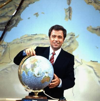 Rund um die Welt Rund um die Welt, Reisequizshow mit Rainer Holbe, Deutschland 1982, hier Holbe mit Globus, Deutschland , Deutschland Copyright: FredxLindinger Nur redaktionelle Nutzung. Editorial usage only. LIN_7601001734 UnitedArchives EDITORIAL USE ONLY