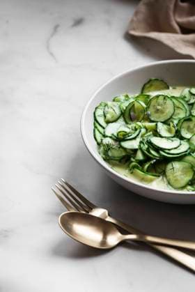 A Bowl of German Cucumber Salad on a marble table with a linen and gold cutlery A Bowl of German Cucumber Salad on a marble table with a linen and gold cutlery Copyright: xHeidixRichterx HR230922-6
