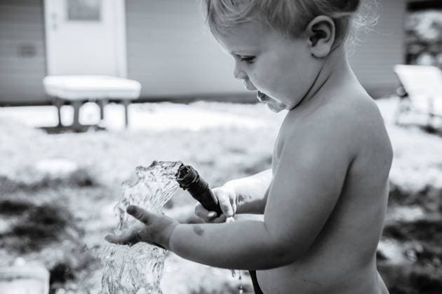 Creative Highlights Symbolbilder Child playing in yard with garden hose in summer McClure, Illinois, United States CR_WEKW2301178B-1109626-01 ,model released, Symbolfoto