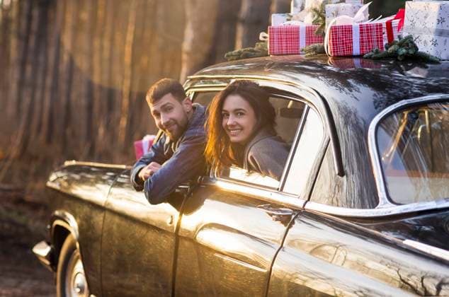 Couple in vintage car with presents on roof Loving man and woman sticking out of retro car windows with Christmas gifts on roof in park Copyright: xZoonar.com DashaxPetrenkox 15980695 ,model released, Symbolfoto ,property released