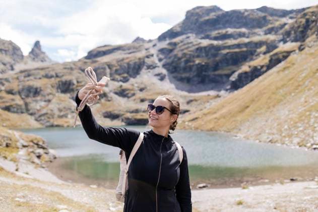 Smiling hiker taking selfie through mobile phone model released, Symbolfoto, MEF00148