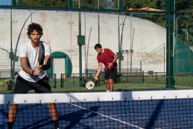 Young man with friend playing paddle tennis at sports court model released, Symbolfoto property released, FMOF01605