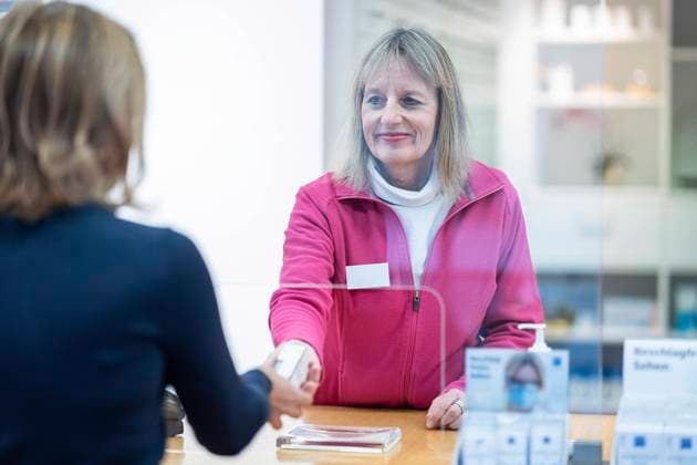 Smiling pharmacist giving medicine to customer model released, Symbolfoto property released, NJAF00124