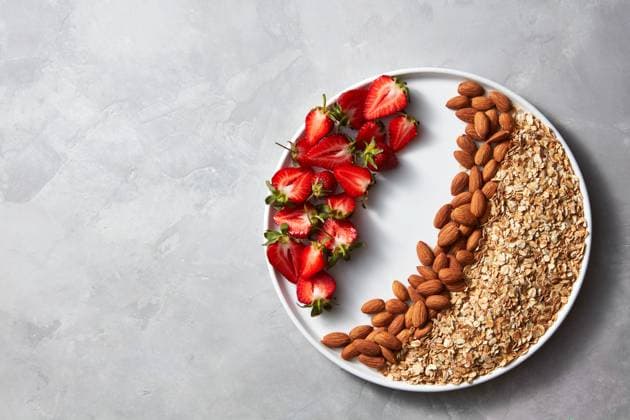 Plate with raw oatmeal, nut and strawberry on a gray concrete background. Ingredients for a healthy breakfast top view Ripe strawberries, almonds and oatmeal flakes in a plate on a gray concrete background with copy space, top view. Dietary and healthy diet. Copyright: xZoonar.com IaroslavxDanylchenkoxphoographerx 12218096