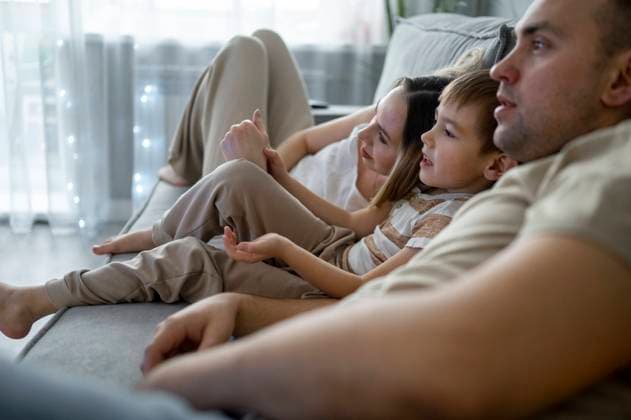 Father and mother watching TV with son at home model released, Symbolfoto property released, ANAF00802