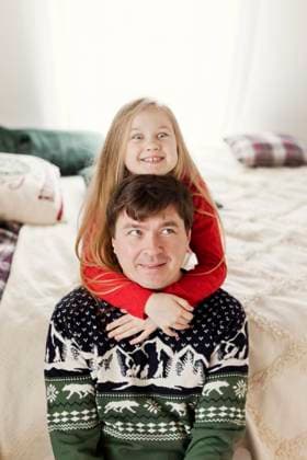 Smiling father with daughter sitting on bed and having fun at home model released, Symbolfoto property released, ONAF00351