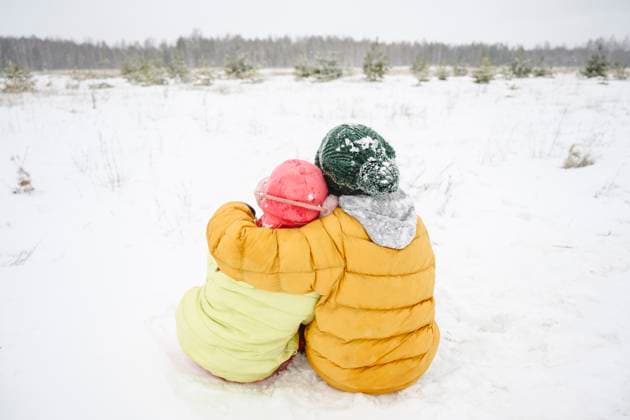 Brother arm around with sister sitting on snow model released, Symbolfoto, EYAF02531