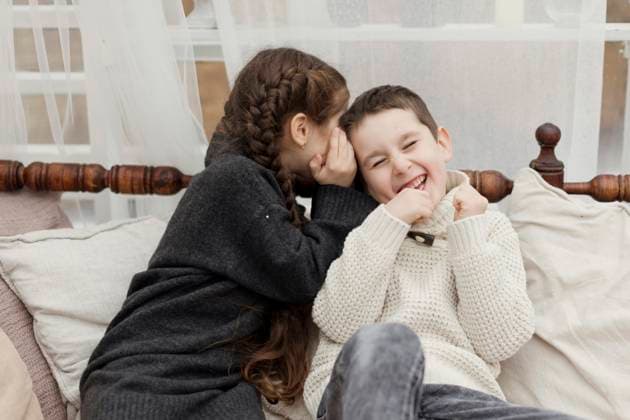Sister whispering in brother s ear on sofa at home model released, Symbolfoto property released, ONAF00369