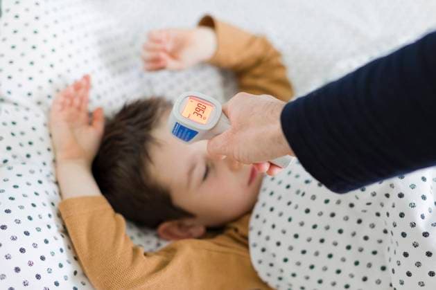 Hand of father measuring temperature of son lying on bed at home model released, Symbolfoto property released, ONAF00387