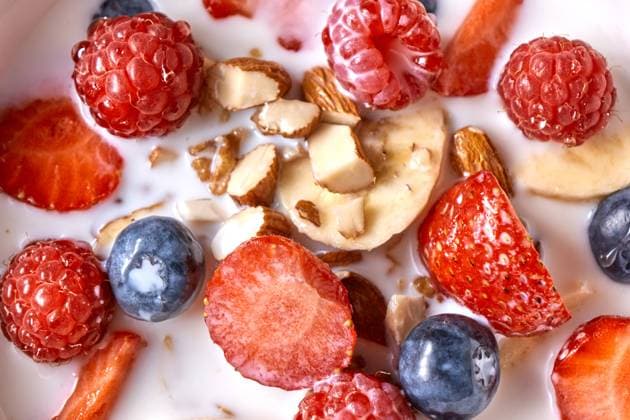 Close up of natural fresh ingredients with healthy breakfast - strawberry, blueberry, chopped almonds, granola and fresh milk. Top view. Homemade granola in a bowl, strawberries, almonds, blueberries, raspberry, organic milk - prepared natural dietary breakfast. Close-up. Top view Copyright: xZoonar.com yaroslavxdanylchenkox 12737696