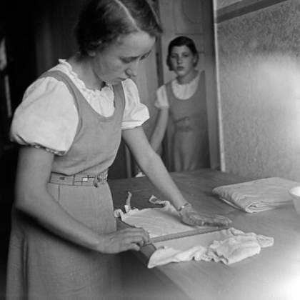 Mädel Landjahr Lager Polle an der Weser Eien BdM Mädel faltet seine Wäsche mit dem Lineal im Landjahr Lager in Polle an der Weser, Deutschland 1930er Jahre. A BdM girl folding her clothes with a ruler at the camp at Polle, Germany 1930s., Polle an der Weser Niedersachsen Deutsches Reich Copyright: xUnitedxArchives M-VerlagxBerlin Lämmel MVB_25002418