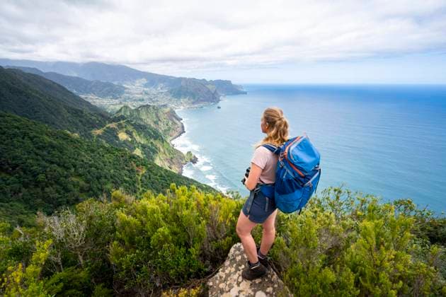 Wanderin am Grat des Pico do Alto, Ausblick auf Steilküste, Küstenlandschaft und Meer, Madeira, Portugal, Europa