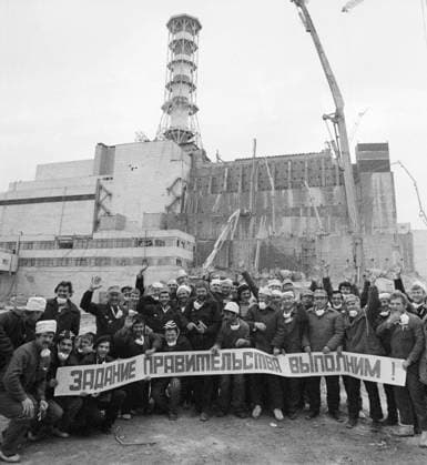 Kiev Region, Ukrainian SSR, USSR. Workers of the Construction Directorate No. 605 of the USSR Ministry of Medium Machine Building celebrates the completion of work on covering the reactor hall during the construction of the Shelter over the destroyed reactor No. 4, cleaning the roof of the reactor No. 3 from radioactive debris and launching the reactor No. 1 at the Chernobyl Nuclear Power Plant after the accident with the raising of the state flag of the USSR on the concrete distribution boom. On April 26, 1986, an explosion occurred at the reactor No. 4 of the nuclear power plant during equipment tests after the shutdown of the reactor for the next scheduled preventive maintenance. The banner reads: We will fulfill the task of the governm  1227223