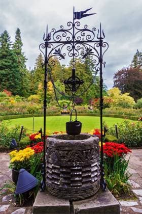Decorative well Scenic decorative park Butchart Gardens on Vancouver Island, Canada. Decorative well on the green lawn Copyright: xZoonar.com kavramx 9839801