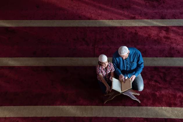 father and son reading holly book quran together islamic education concept muslim prayer father and son in mosque praying and reading holly book quran together Copyright: xZoonar.com benisxarapovicx 16978956 ,model released, Symbolfoto ,property released