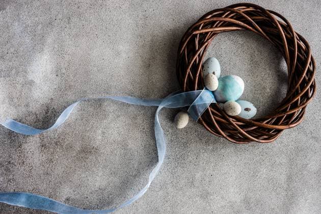 From above easter holiday concept with grape vine wreath decorated with pale blue ribbon on grey concrete background AnnaBogush_ID12587_382567_009 Copyright: xAnnaxBogushx Model Released