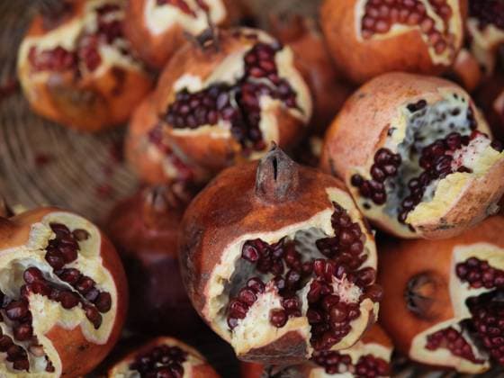 Delicious whole fresh pomegranates with seeds placed on wooden background of bowl in daylight PeterKarasev_ID10653_322789_009 Copyright: xPeterxKarasevx Model Released