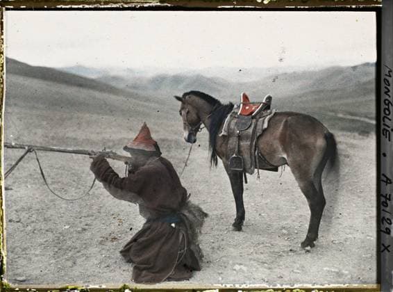 RECORD DATE NOT STATED Around Ourga, Mongolia Mongoli Hunter descended from horse demonstrating the handling of the stone rifle , 1913 - Mongolia - StÃ phane Passet - (July 6-25) (French - ï»¿Aux environs d Ourga , Mongolie Chasseur mongol descendu de cheval faisant une dÃ monstration du maniement du fusil Ã pierre). Animal transport, horse, landscape, real animal, costume, equidated, weapon, hairstyle , headgear, man, Transport, nature , environment, animal, clothing, human beings Copyright: xpiemagsx AKahnlpie020223-1692 !ACHTUNG AUFNAHMEDATUM GESCHÄTZT!