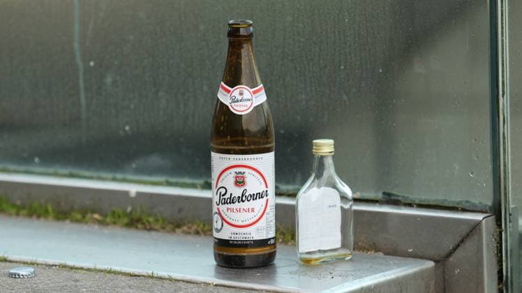 Eine leere Bierflasche der Marke Paderborner sowie leere Spirituosenflasche stehen auf einer Treppe in der Hamburger Altstadt. Symbolbild Alkoholsucht. Altstadt Hamburg *** An empty beer bottle of the brand Paderborner as well as empty liquor bottle stand on a staircase in the Hamburg old town symbol picture alcohol addiction old town Hamburg