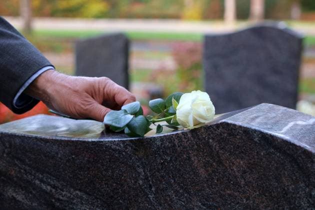 Eine weisse Rose als Zeichen der Trauer wird auf einen Grabstein gelegt a white rose as a sign of mourning is placed on a gravestone BLWS680637 *** a Whites Rose as Character the Grief will at a Gravestone laid a White Rose As a Sign of Mourning IS placed ON a Gravestone BLWS680637 Copyright: xblickwinkel R.xRebmannx