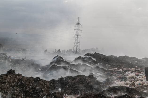 February 16, 2023, Nakuru, Kenya: A high voltage electricity pylon is seen behind a plume of smoke from burning garbage, mostly plastic, textiles among other waste at Gioto Dumping site. An investigation by Kenyan nonprofit environmental group Clean-Up Kenya and Wild light for the Changing Markets Foundation found that European countries are dumping 37 million items of unusable plastic clothing in Kenya every year. The investigation found that more than one in three pieces of used clothing shipped to Kenya are of substandard quality and immediately the bails are opened, they become waste. Nakuru Kenya - ZUMAs197 20230216_zab_s197_042 Copyright: xJamesxWakibiax