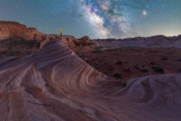 Creative Highlights Symbolbilder Silhouette of anonymous traveler standing on rocky formations in Valley of Fire State Park and admiring spectacular starry night sky with Milky Way, Model released JuanLopez_ID12791_388061_008 Copyright: xJuanxLopezx MR