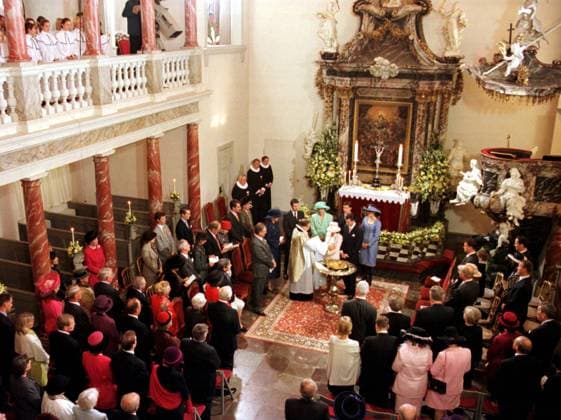 SCANPIX SWEDEN, 1999-11-06. Danmark:s minsta prins döps. I Fredensborgs slottskyrka. Lill-prinsen är son till prins Joachim och prinsessan Alexandra av Danmark. Han har fatt namnen Nikolai William Alexander Frederik. Bilden: Alexandra star vid dopfunten med lill-prinsen i famnen. Intill henne star prins Joachim. Prästen, Christian Thodberg, läser ur en bok. Bakom dem star (fr.v): Prins Henrik, drottning Margrethe, kronprins Frederik; gudfar, Camilla Flinth; gudmor, Peter Steenstrup; gudfar, Nicola Baird; gudmor. Flinth har en mintgrön dräkt med hatt. Baird har en bla dräkt med hatt. Prinsessan har en rosa dräkt med hatt. Männen bär kostym. Runt dem star människor askadare. I bakgrunden ses altaret. Bilden tagen ovan  Copyright: xUlfxPalm TTx 50040