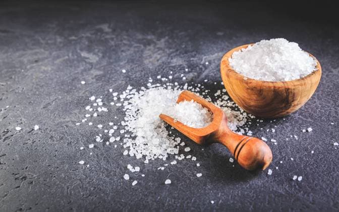 Pure natural sea salt in wooden bowl and wooden spoon on black background Pure natural sea salt in wooden bowl and wooden spoon on black background Copyright: xZoonar.com IngridxBalabanovax 19247414