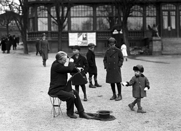 ARKIV 1931 Man spelar pa sag vid Djurgardsslätten utanför Skansen. Pojkar i keps lyssnar. Flicka kastar en slant i hatten. Saw player at Djurgarden. Stockholm Sverige x1900x *** ARCIVE 1931 Man plays on a saw at Djurgarden outside Skansen Boys in caps listen Girl throws a coin in her hat Saw player at Djurgarden Stockholm Sweden x1900x  Copyright: xTTxHISTORICALx SAGFIOL