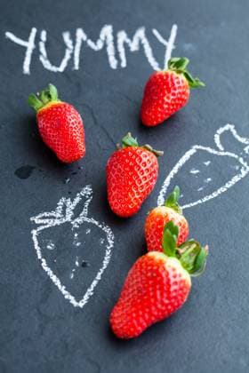 Fresh whole strawberries and chalk drawings and yummy word on dark background Copyright: xElinaxManninenx xDesignxPicsx , 32084976 Copyright: 32084976