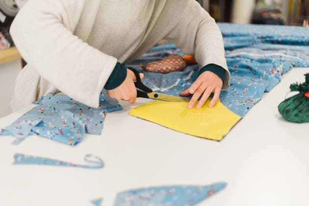 Unrecognizable female tailor in casual sweater cutting piece of colorful fabric with scissors while working on project in creative atelier, Model released, Property released AlbaCaro_ID12631_384004_048 Copyright: xAlbaxCarox MR