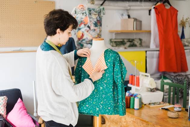 Concentrated female tailor in casual clothes with measuring tape on neck standing near mannequin while preparing clothing for work in creative studio, Model released, Property released AlbaCaro_ID12631_384063_072 Copyright: xAlbaxCarox MR