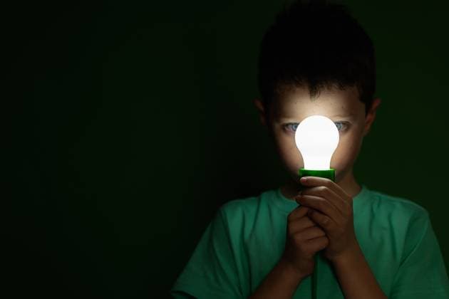 Creative Highlights Symbolbilder Focused cute preteen kid in green t shirt standing in dark room and holding light bulb close to face on green background, Model released HodeiUnzueta_ID12899_391763_009 Copyright: xHodeixUnzuetax MR