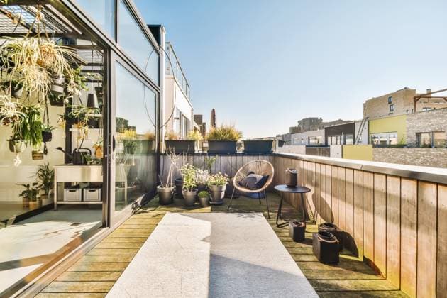 Spacious contemporary veranda with wooden floor and potted plants against cloudless blue sky on sunny day ProCreators_KeaBoumanstraat84_30 Copyright: xProxCreatorsx Model Released